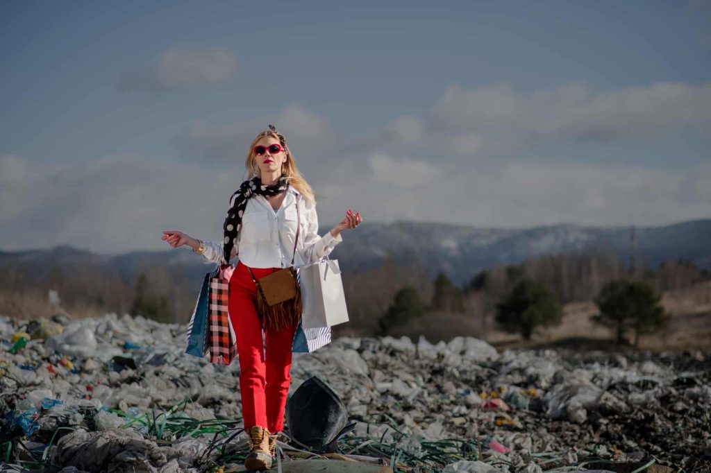 A fashionable modern woman with shopping bags on landfill.