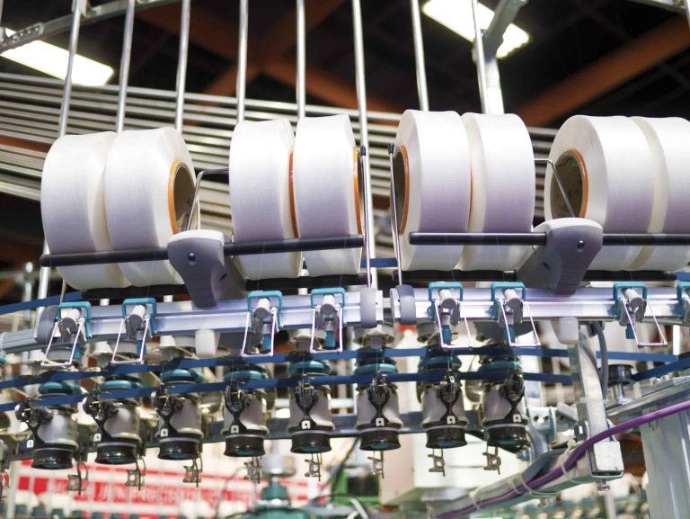 Textile industry - yarn spools on spinning machine in a textile factory